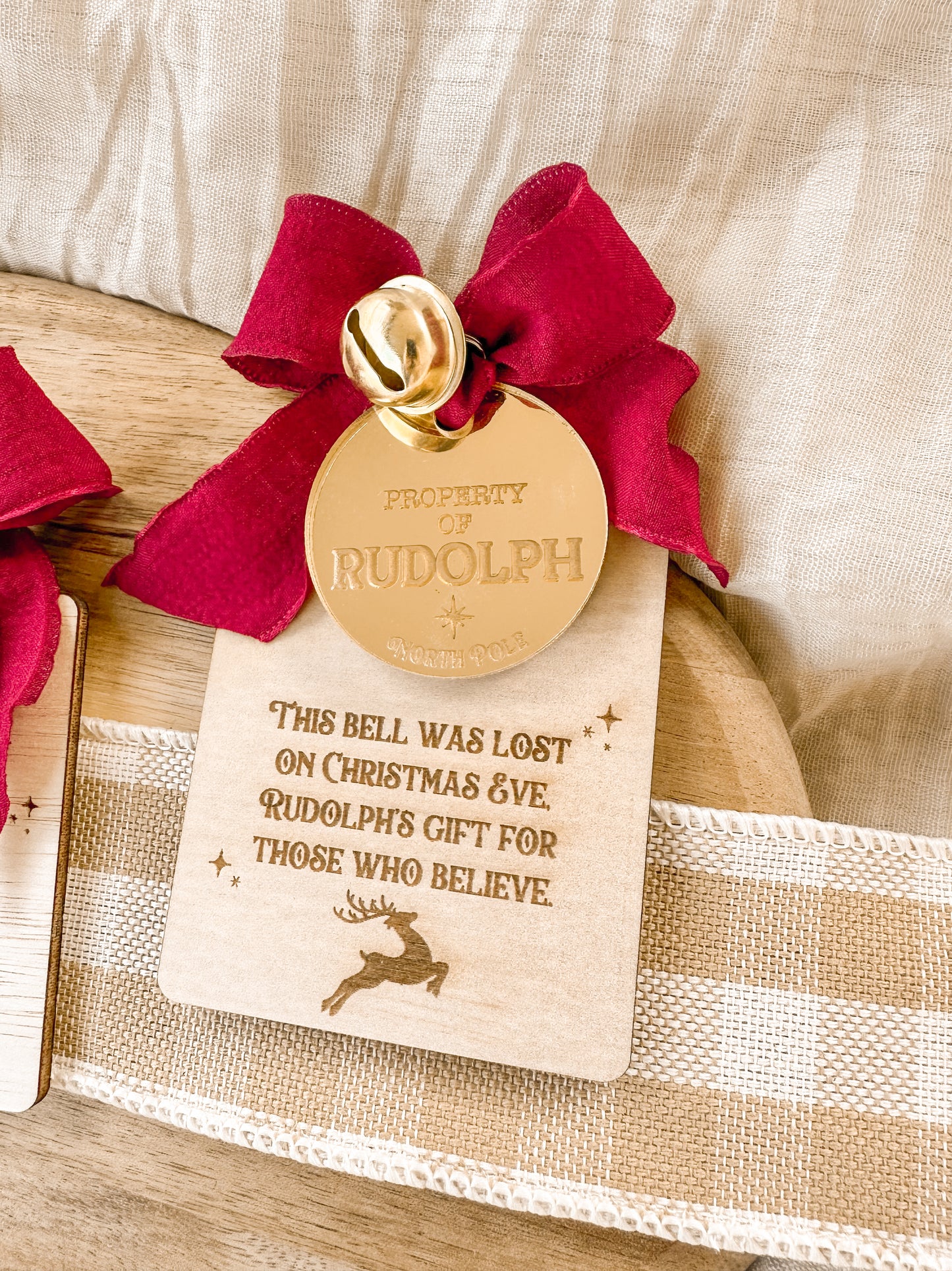 Rudolph's lost bell with decorative bell, red ribbon and wooden plaque that can be personalised. Reindeer's lost jingle bell